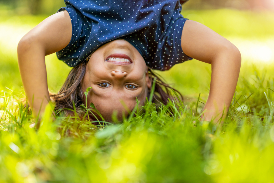 child-doing-hand-stand-in-park